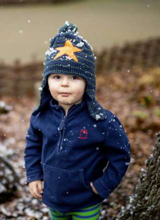 A young boy playing in the snow during the festive period.