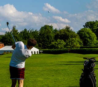 A man swinging his golf club while playing at our Appletree Holiday Park in Lincolnshire. image