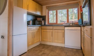 The interior of one of our Luxury holiday lodges. There's a kitchen area with many appliances, and an island in the centre. image