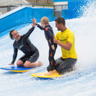 A family enjoying a surf on the Flowrider at our Cornish Resort, Retallack Resort & Spa.
