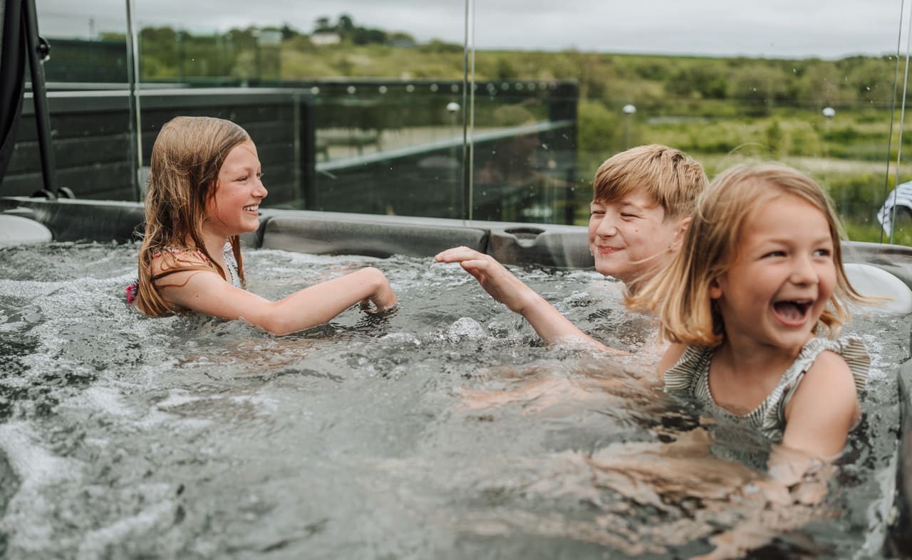 Three young children playing outside in one of our hot tubs at Retallack Resort & Spa. image
