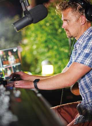 A male performing on a a set of DJ decks.