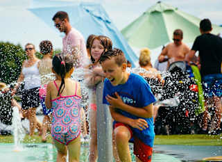 Young children playing in our outdoor splash pad. image