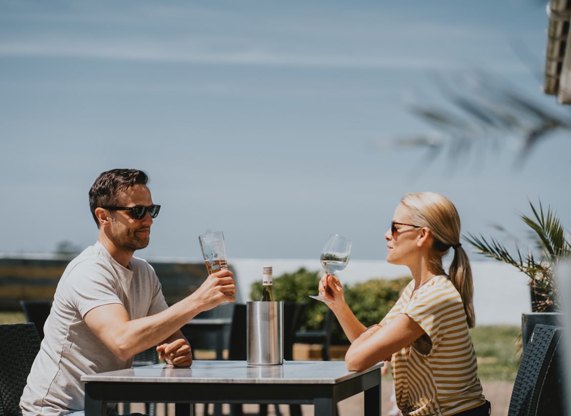 A couple sat outside enjoying a glass of wine together at The Sunset Bar and Eatery, Newperran, on a summers day. image
