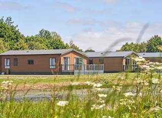 Over lake view of our lodges available to holiday at, Appletree Holiday Park. image