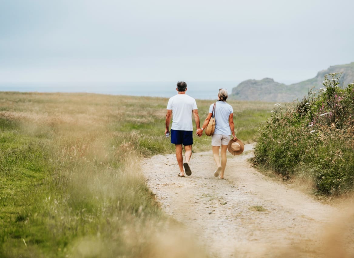 A happy couple walking hand in hand near one of our holiday parks. image