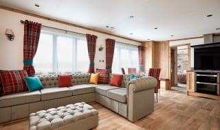 The Heartwood holiday home lounge area. This space has a large sofa, a dining area, and décor that reflects Scottish baronial living. image