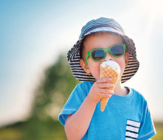 A young boy enjoying an ice cream on a summers day.