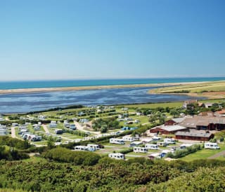 An aerial view of our stunning park, East Fleet Farm, with views of the lagoon and sea in the distance. The perfect holiday destination.