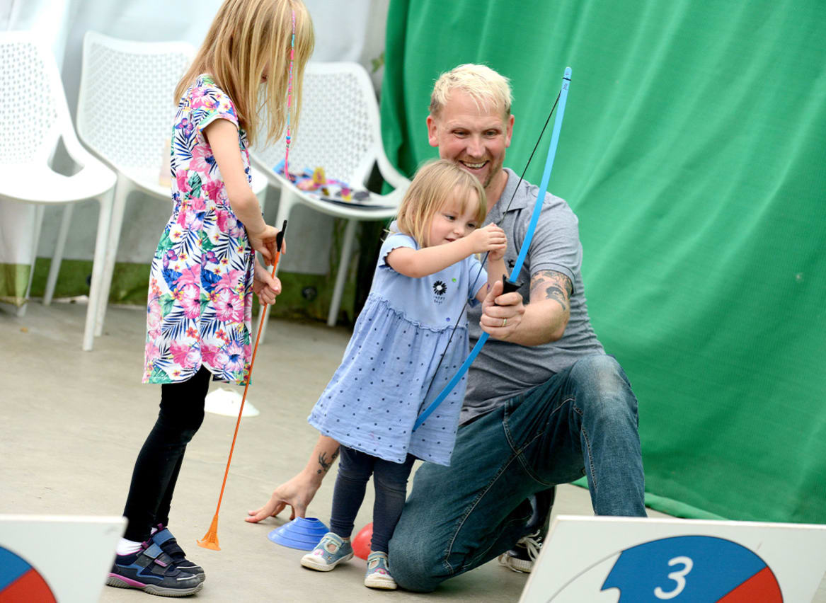 A family taking part in the Mini Archery activity. image