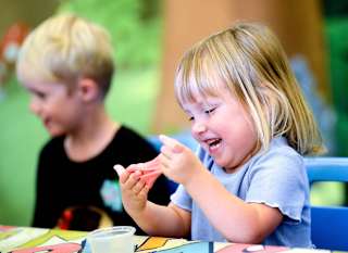 A young girl participating in our slime workshop activity. image