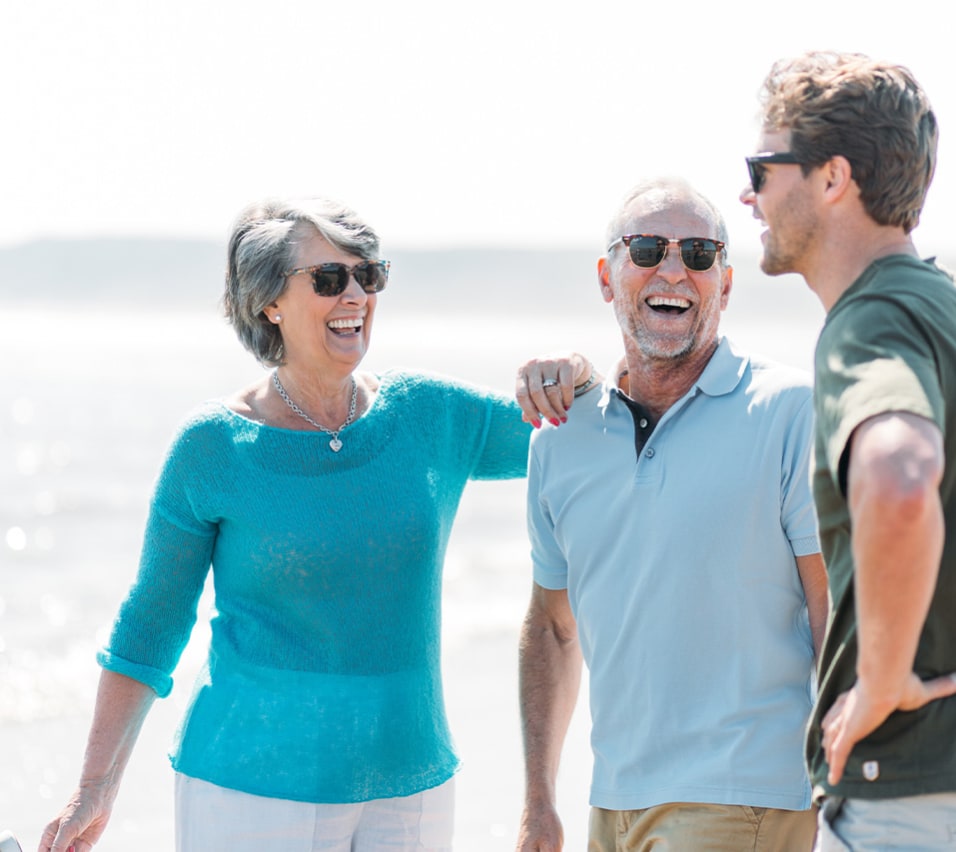 Mother, son and father all in sunglasses laughing together on the beach at Bay Filey. image