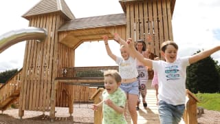 A group of children playing on a wooden climbing frame at Wyvernwood.