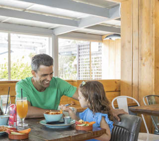 A father and daughter enjoying some food together. image
