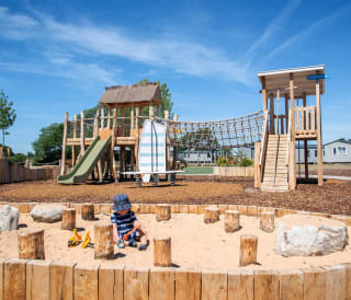 Child playing in the sand at our adventure playground in the sunshine at Mill Rythe Holiday Park, Hampshire.