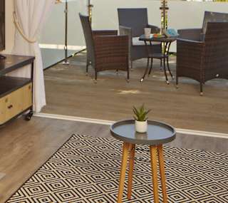 The living area of one of our spacious Beach Lodges, with stunning views of the sea from the balcony. Book your holiday now! image