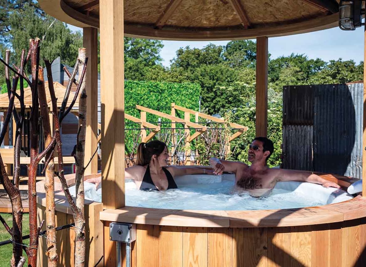 Couple relaxing in the hot tub, sinking into the bubbles. The perfect way to stay! image
