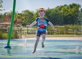 Child running through splashpad at Appletree Holiday Park. image