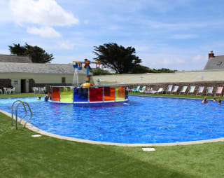 The outdoor heated swimming pool with splash zone at our resort in Cornwall, Bude, on a summers day.