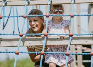 A mother and daughter playing in our adventure playground on a sunny day. image