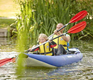 A man and child canoeing down the lake. image