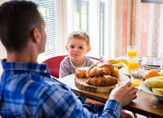 A young family enjoying breakfast in our exclusive accommodation, The TriBeCa. Book your holiday today! image