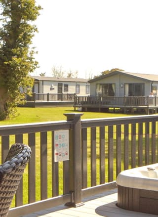 The decking with a hot tub of one of our stunning accommodations at St Helens Coastal Resort.