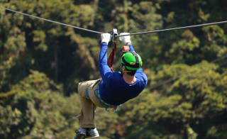A man zip-wiring through the forest. image