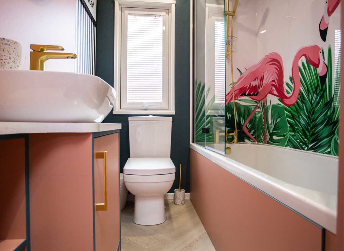 A clean and white bathroom with pink wooden accents on the washbasin and bathtub. The white shower curtain has a pink flamingo on it. image