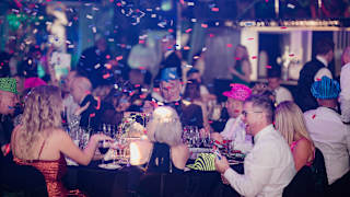 A group of people enjoying a party at one of our holiday parks. There is confetti falling around.