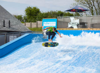A man performing on our Retallack Resort and Spa FlowRider surfing machine. image