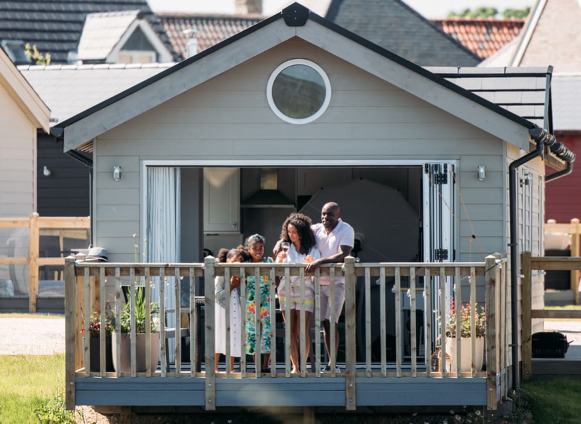 A family on the decking looking out onto the lake at our stunning resort, The Bay Filey. image
