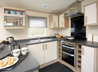 The kitchen area of our bright and spacious comfort static caravan. The perfect way to stay. image