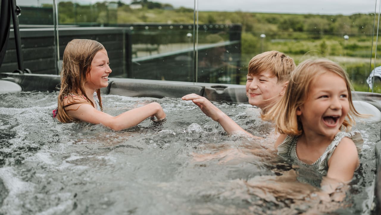 Three young children playing outside in one of our hot tubs at Retallack Resort & Spa.