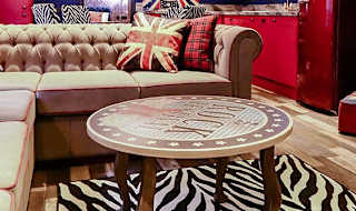 The lounge in our Rockstar holiday home. There’s a spacious kitchen, a large TV and sofa, and a theme of red, white, and blue Great British colours. image
