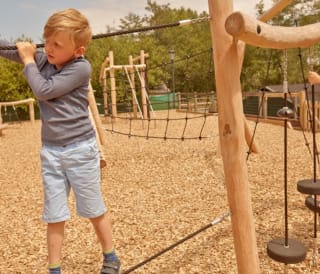 Two children playing in the outdoor adventure playground at our Isle of Wight holiday park, The Lakes Rookley.