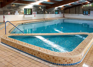An image of a indoor swimming pool with clear blue water at one of our holiday parks. image