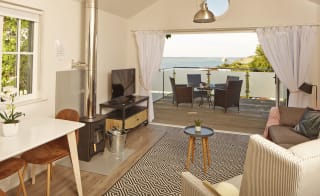 The living area of one of our spacious Beach Lodges, with stunning views of the sea from the balcony. Book your holiday now! image