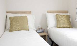 The twin bedroom in our bright and spacious comfort static caravan. The perfect way to stay. image
