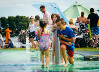 Young children playing in our outdoor splash pad. image