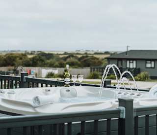 One of our stunning accommodations with a hot tub and a bottle of bubbly, relaxation at it's finest!