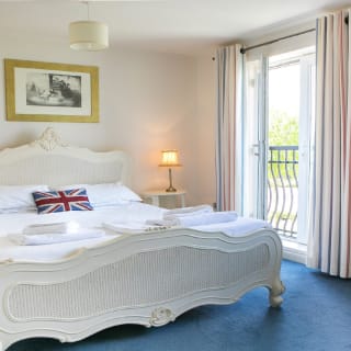 A double room in one of our apartments. Inside the room, a large bed can be seen, with access to a balcony area.
