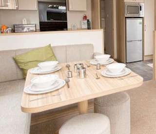 The living and dining area of our bright and spacious comfort static caravan. The perfect way to stay.