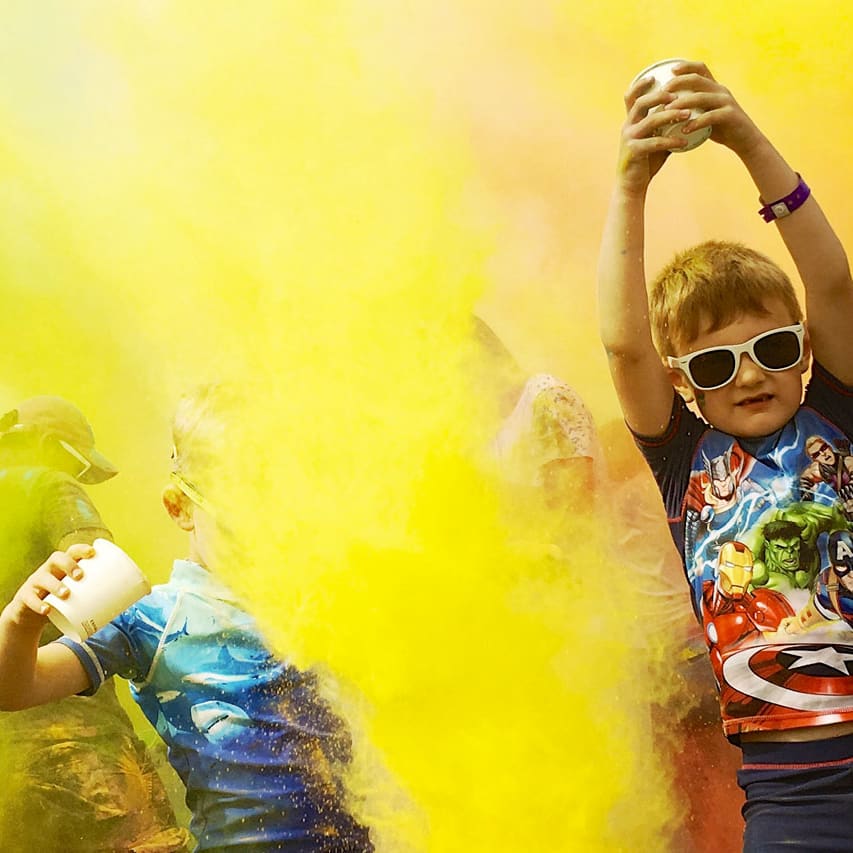 A colour festival event at one of our holiday parks. The young children are splashing colourful substances into the air at our incredible event. image