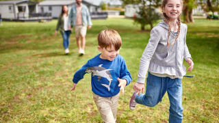Two young children running towards the camera smiling.