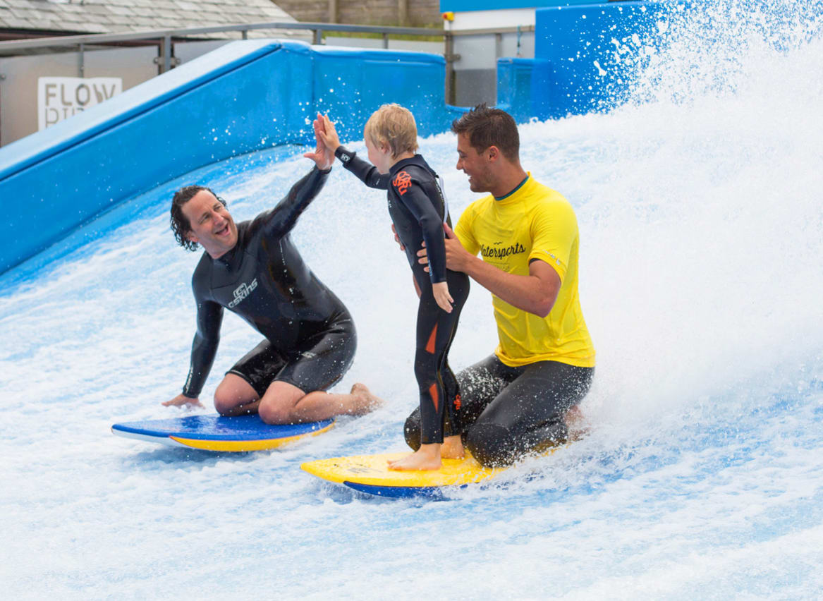 A family enjoying a surf on the Flowrider at our Cornish Resort, Retallack Resort & Spa. image