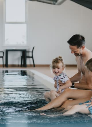 A young family playing in the indoor swimming pool at our holiday resort in Cornwall, Newperran.