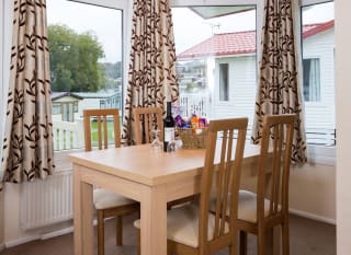 The interior of one of our Superior lodges. There's a dining area with three large windows. image