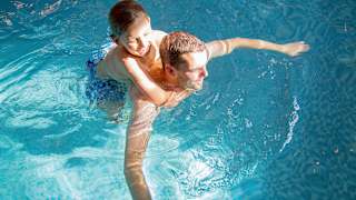 A father and son duo having a swim in one of our indoor pools at our static caravan holiday parks.