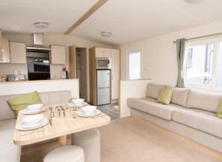 The living and dining area of our bright and spacious comfort static caravan. The perfect way to stay. image